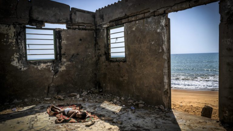 Fotografia de mediu a anului. Povestea din spatele copilului care doarme între ruinele unei case, pe o plajă din Ghana