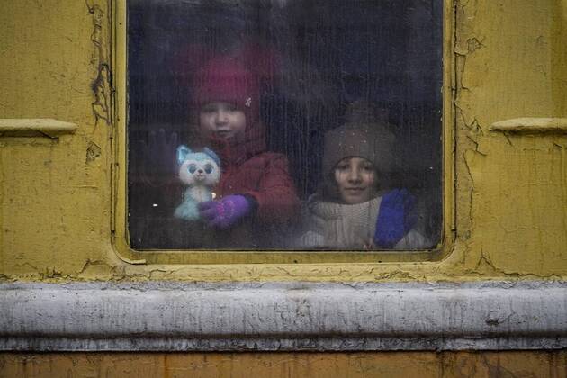 Copii privind prin fereastra unui tren neîncălzit care pleacă din Kiev spre Lviv, joi, 3 martie 2022, Ucraina. Foto: Vadim Ghirda