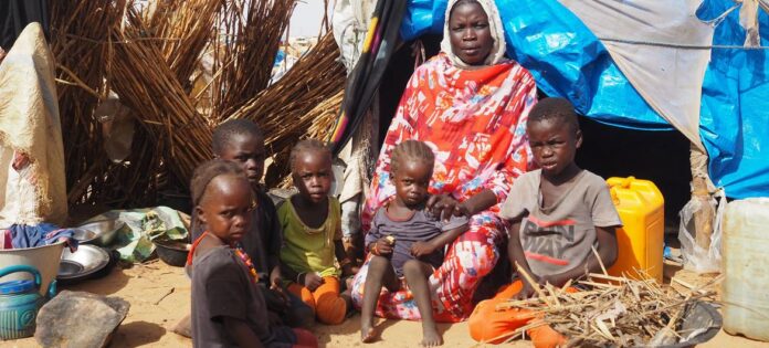© UNHCR/Ying Hu O familie de refugiați într-o tabără din Sudan.